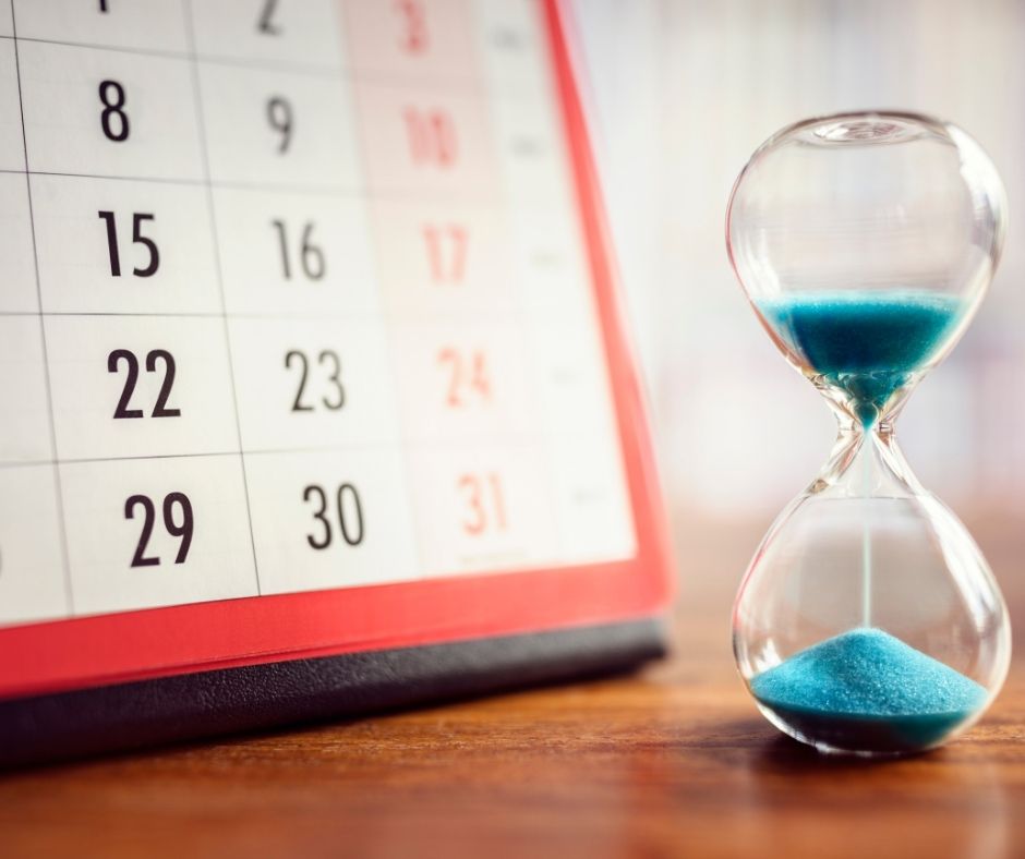 A calendar and hourglass with blue sand indicating time running out. 