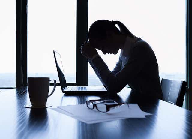 woman looking distraught over her computer